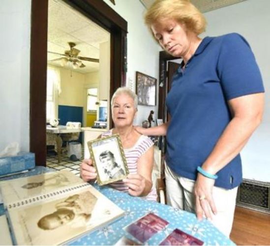 Mary Ann Brubaker and her daughter Lisa Schenzel looking at photos of Maureen