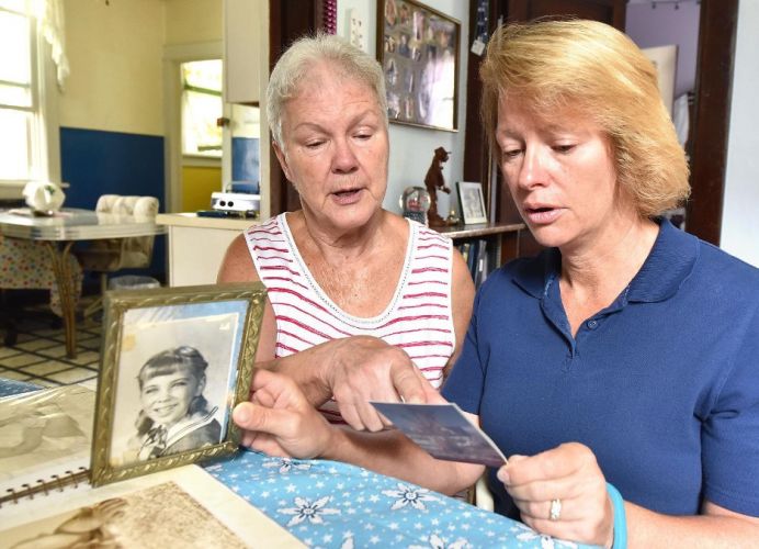 Mary Ann Brubaker and her daughter Lisa Schenzel looking at photos of Maureen
