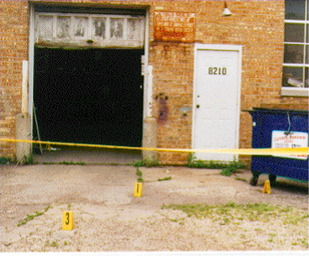garage with yellow tape and evidence markers outside